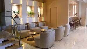 A modern living area with sofas, a coffee table, and a staircase with a railing.