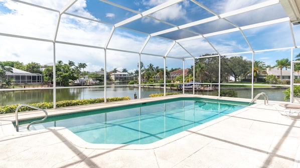 Una piscina con vistas claras de los alrededores, incluyendo un cuerpo de agua y edificios lejanos.
