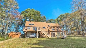 A two-story house with a balcony, a covered porch, and a small shed. - Timber frame home only 5 minutes from Windham Mountain - perfect for 2 families! (Windham)