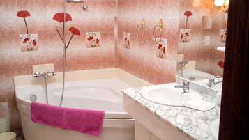 Ein Badezimmer mit einer Badewanne, einem Waschbecken und einem Waschtisch mit Schubladen.