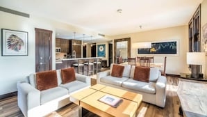 Ein modernes Wohnzimmer mit zwei Sofas, einem Couchtisch und einem Essbereich mit Tisch und Stühlen.