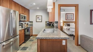 Eine moderne Küche mit Granit-Arbeitsplatten, Edelstahlgeräten und Holzschränken.