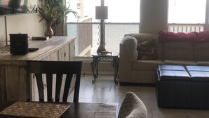 Un salon comprenant un canapé, une table basse et un coin repas avec une table et des chaises.