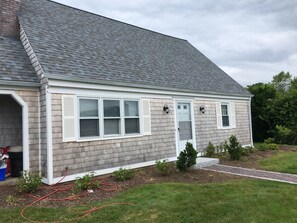 A single-story house with a grey shingle roof, white trim, and a small front yard with a pathway. - WALK TO BEACH- NEWLY RENOVATED (Narragansett)