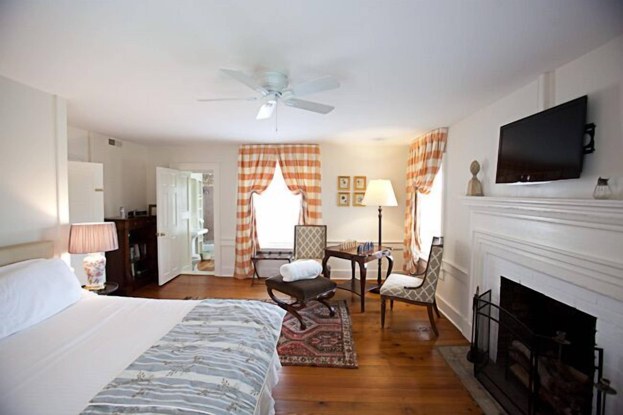 Une chambre d’hôtel équipée d’un lit, d’un bureau, d’une chaise, d’une cheminée et d’un téléviseur.