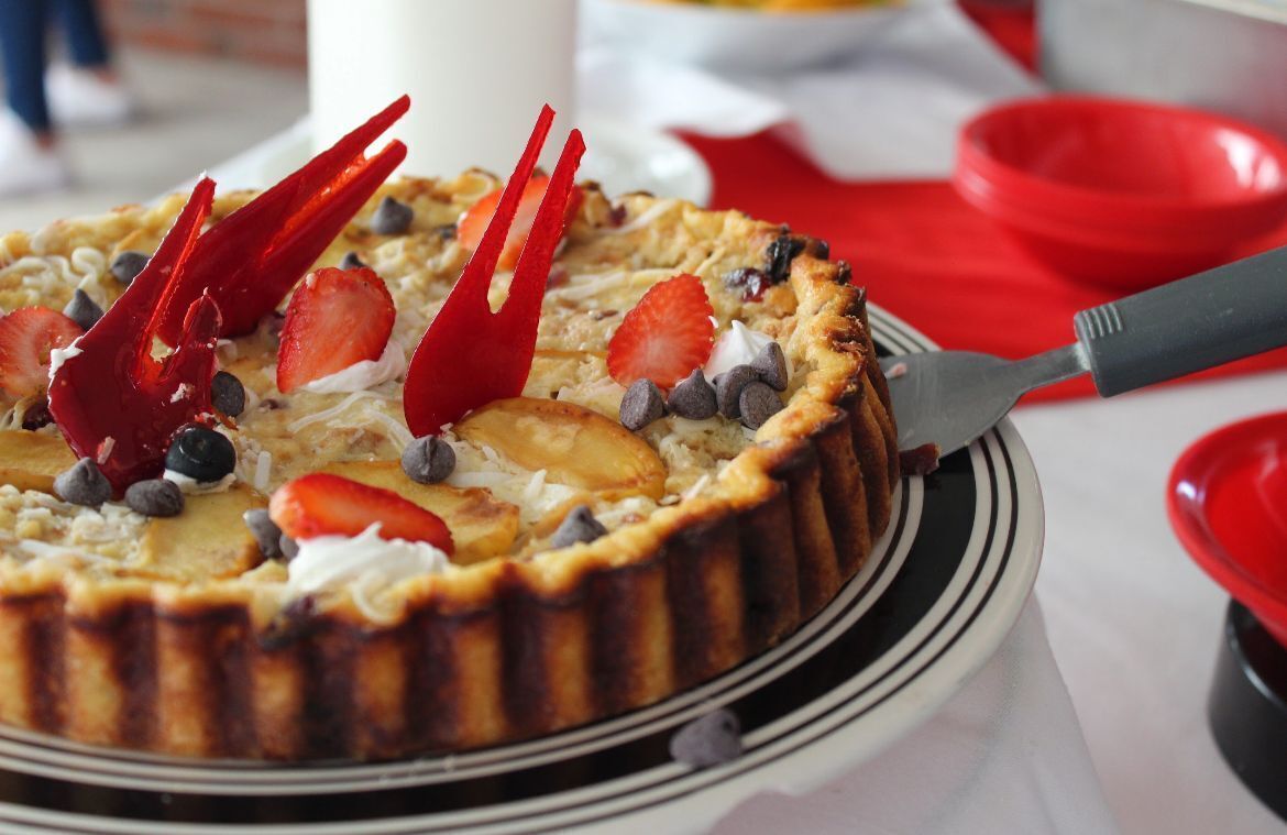 Un postre con fresas, arándanos y chispas de chocolate sobre un plato.