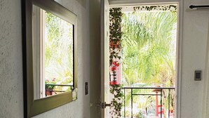 Ein Hotelzimmer mit großem Fenster, einem an der Wand befestigten Flachbildfernseher, einer Wasserflasche und einer Fernbedienung auf der Ablagefläche.