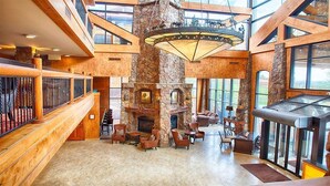 A spacious lobby with a stone fireplace, wooden staircase, and large windows. - Luxury Studio!! Gym, Pool, Sauna, Spa, Canyons Gondola Ski In/Out (Park City)