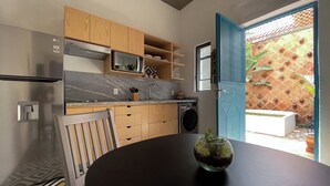 A modern kitchen with wooden cabinets, a built-in microwave, and a washing machine.
