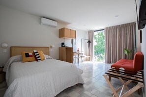 Una habitación de hotel con cama, escritorio, silla y televisión.