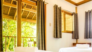 A room with two beds, a window with curtains, and a view of greenery outside. - Amihan Bungalows (Cloud Nine) (General Luna)