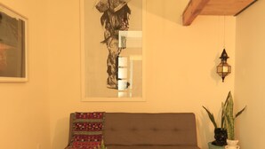 Un salon chaleureux avec un canapé marron, une table basse en bois et un tapis noir.