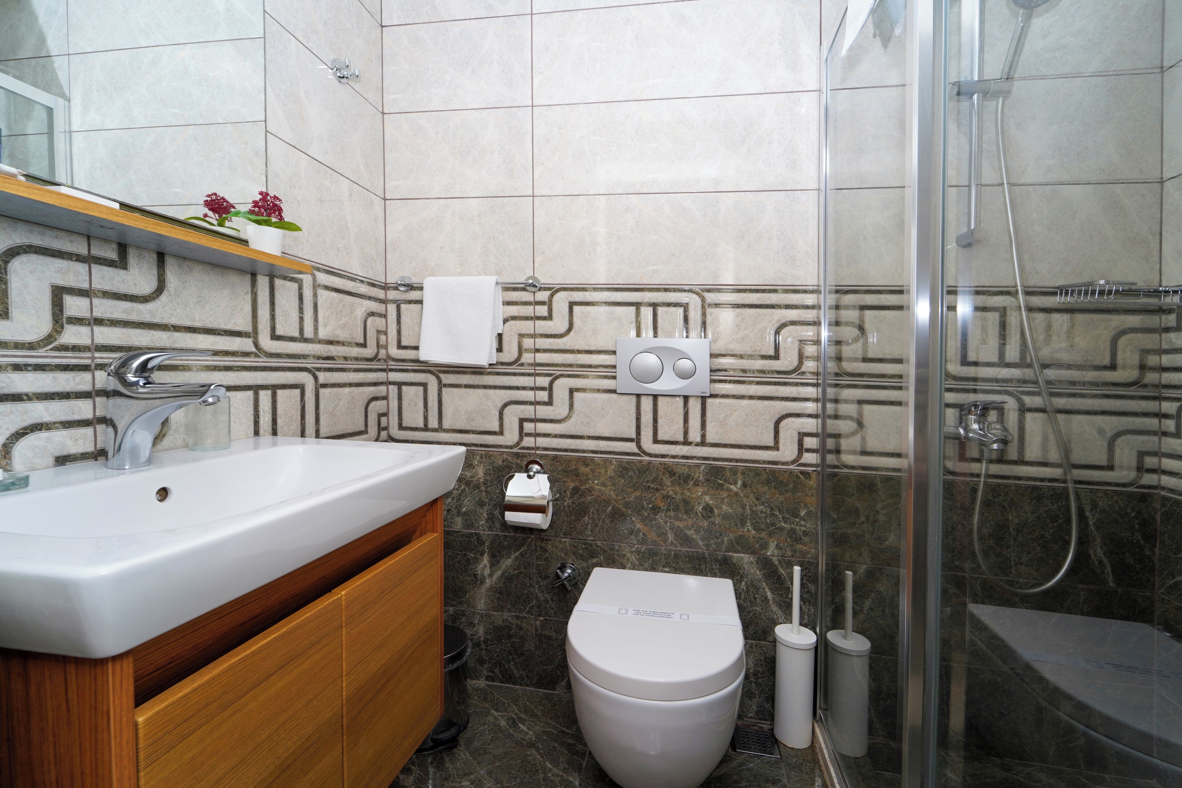 A modern bathroom with a sink, toilet, and shower.