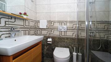A modern bathroom with a sink, toilet, and shower.