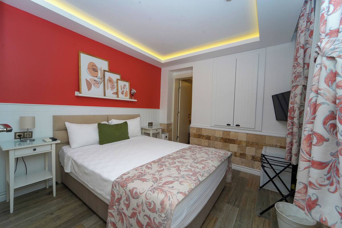 Une chambre d’hôtel avec un lit, une table de chevet, une lampe et une œuvre d’art au mur.