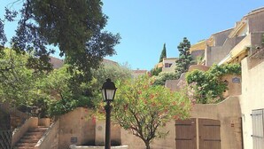 Ein Innenhof mit einer Laterne, einem kleinen Baum und einer Steinsitzbank.