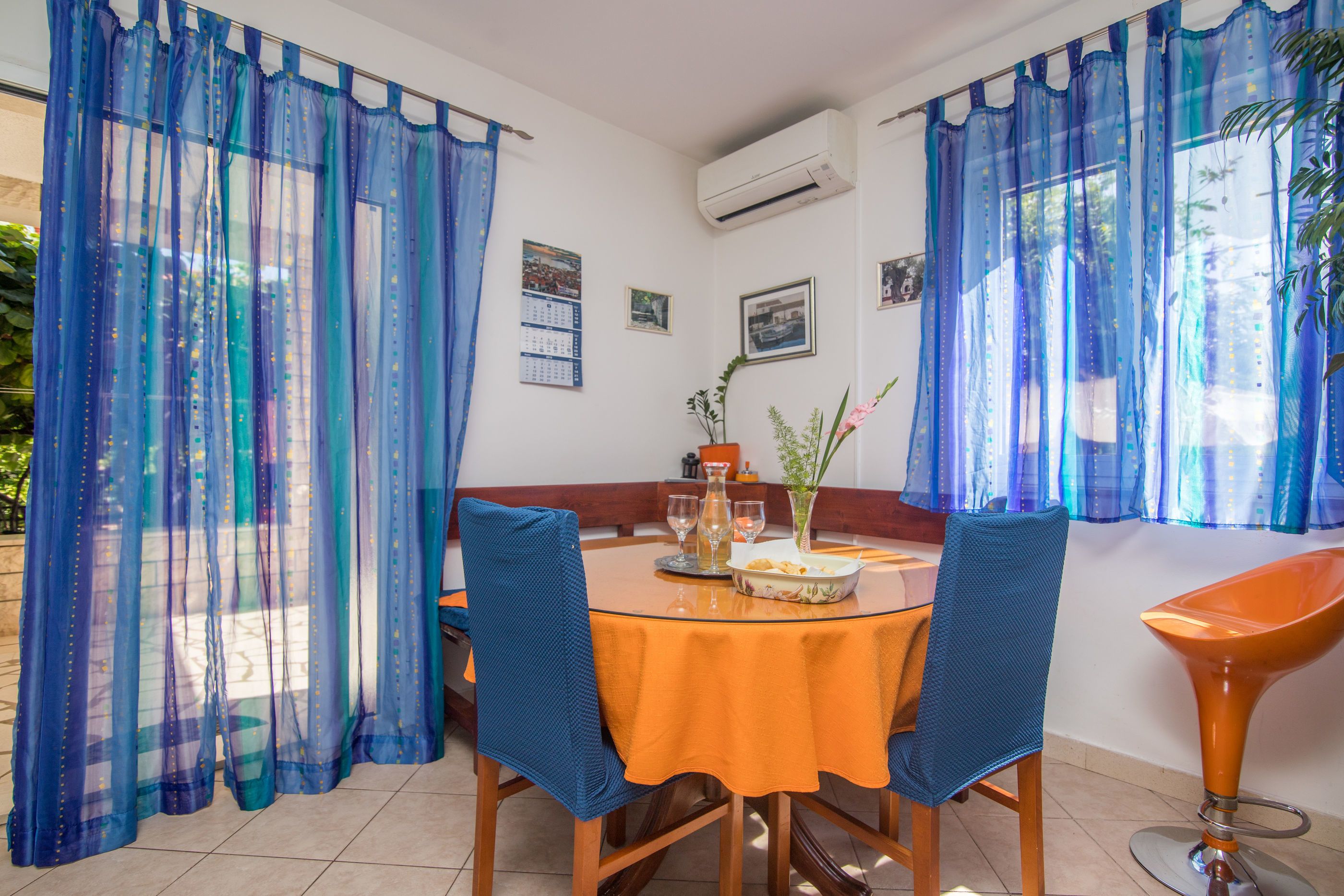 A dining area with a round table, chairs, and a vase of flowers.