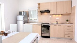 Une cuisine de taille réduite, équipée d’une cuisinière, d’un four et d’un réfrigérateur.