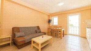 Una sala de estar con sofá, una mesa de centro y una zona de comedor con sillas y mesa.