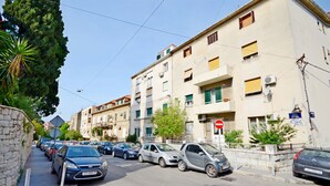 A street lined with parked cars and a row of multi-story buildings with balconies and satellite dishes. - Apartment Marijo (Split)