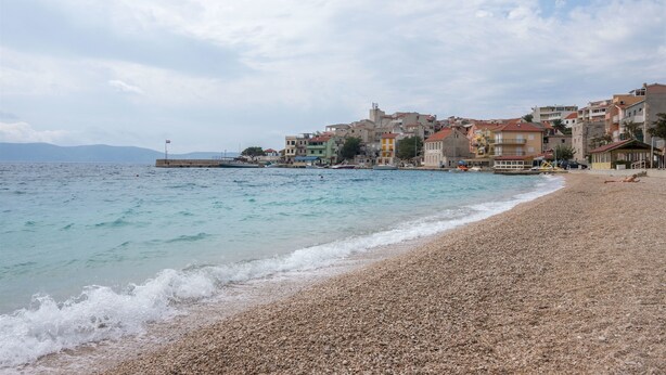 A pebble beach with buildings in the background. - Apartments Ante (Igrane)
