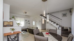 A modern living space with a dining area, staircase, and a kitchen. - House Jadranka (Supetar)
