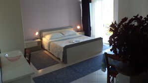 A bedroom with a bed, bedside tables, a desk, and a chair. - Apartments Andela (Brsec)