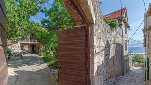 Eine enge Kopfsteinpflasterstraße mit einer Holztür und steinernen Häusern.
