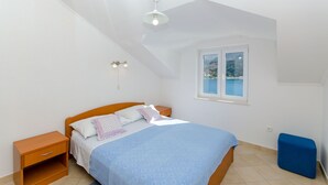Ein Schlafzimmer mit Bett, Nachttisch und Fenster mit Blick.