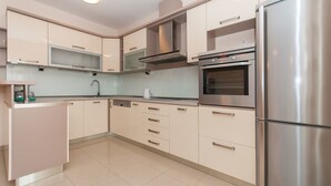 Una cocina moderna con electrodomésticos de acero inoxidable, armarios color beige y horno empotrado.