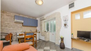 A compact living space with a kitchenette, a dining area, and a seating area. - Apartments Anita (Slatine)