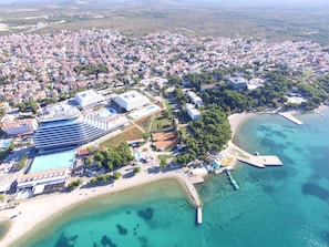 Vista aérea de un pueblo costero con un hotel grande que cuenta con varias piscinas y una zona de playa.