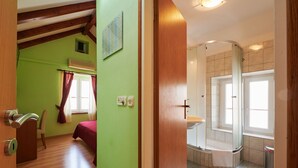 A room with a bed, a chair, a window with curtains, and a door with a handle. - Apartment and Room Ivica (Trogir)