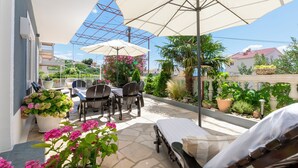 Un patio con mesa y sillas, una cama y plantas en macetas.