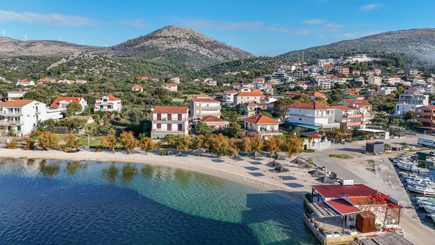 A coastal town with buildings, a beach, and a marina.