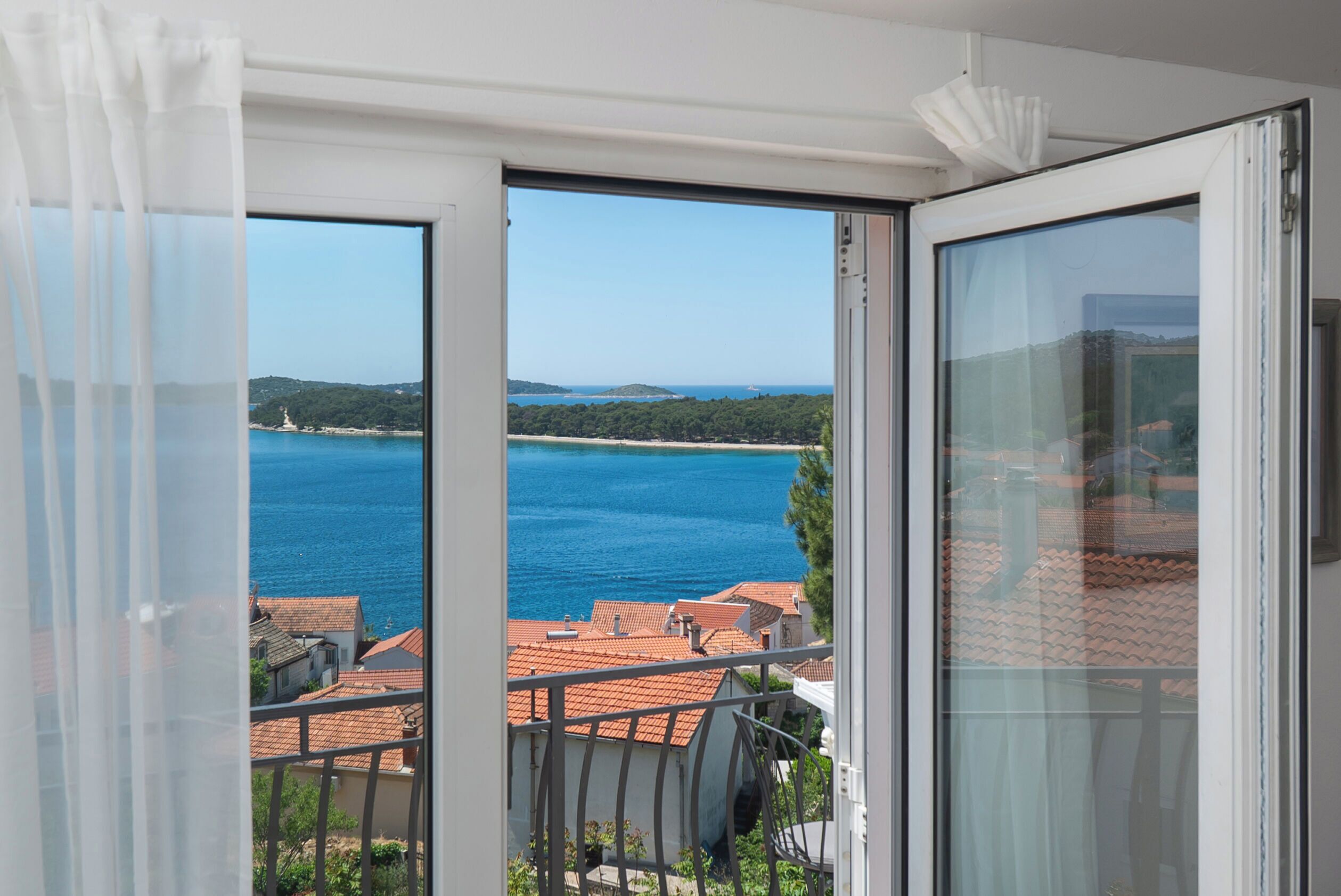 A balcony with a view of a body of water and buildings.