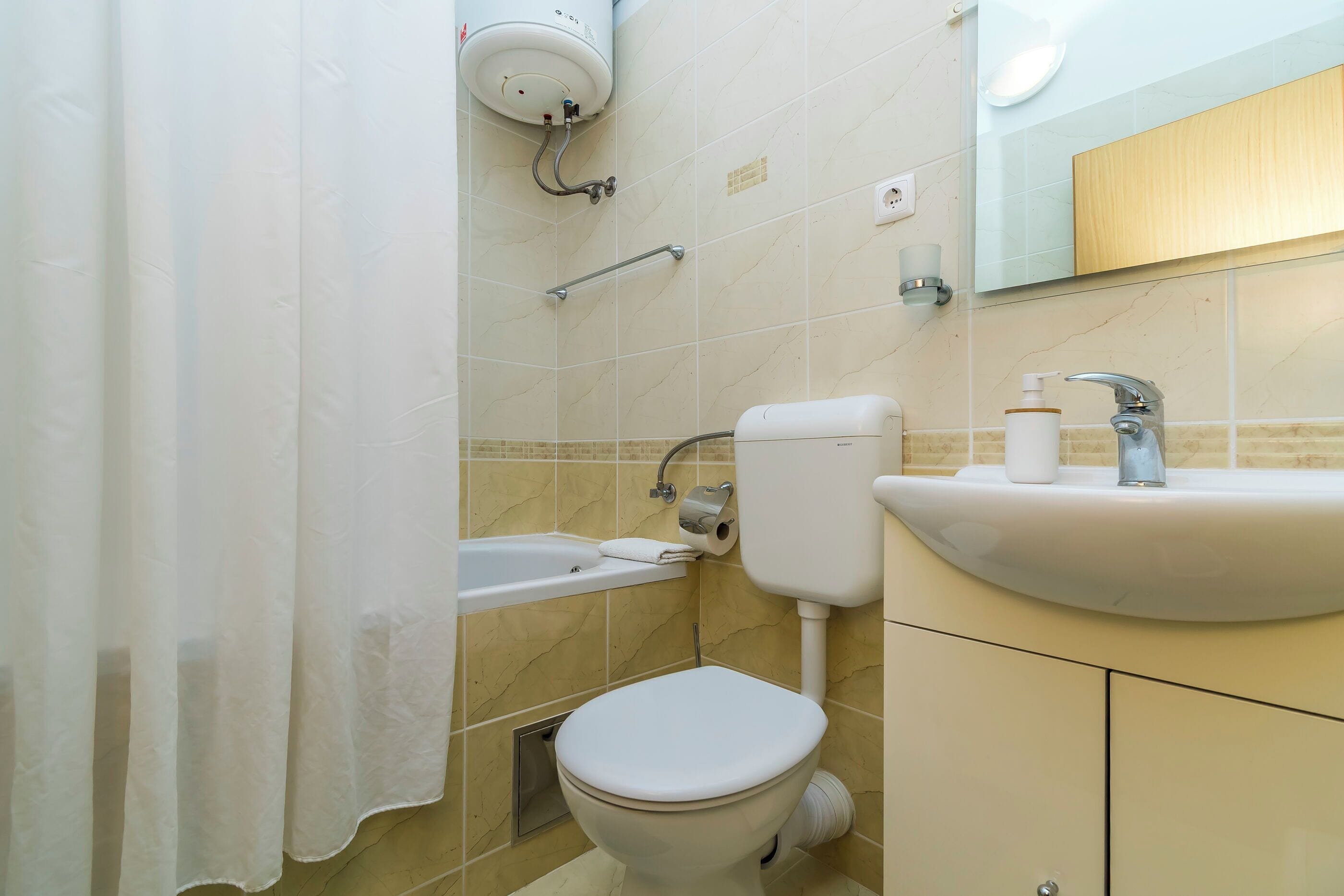A bathroom with a toilet, sink, and shower.