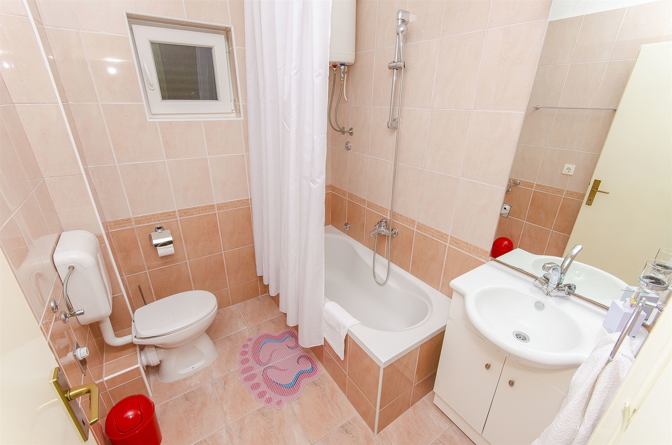 Een badkamer met toilet, badkuip en wastafel.