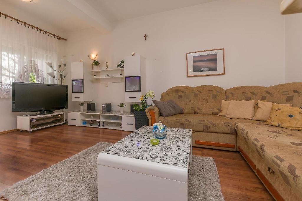 A living room with a TV, sofa, coffee table, and decorative items.