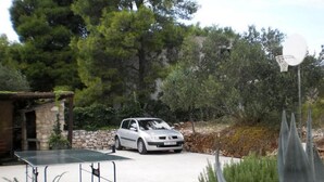 A car parked in a driveway with a ping pong table and a satellite dish. - Apartment Tomislav (Okrug Gornji)
