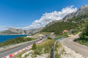 A coastal road with a mountain backdrop, a winding road, and a view of the sea. - Apartment Josipa (Omis)
