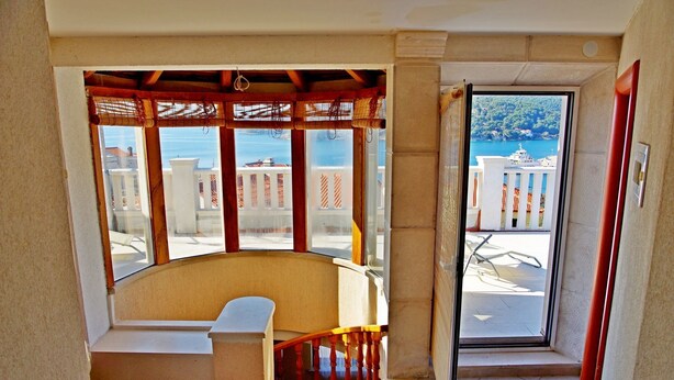 A balcony with a view of the sea, a wooden staircase, and a seating area. - Apartment Mario (Sumartin)