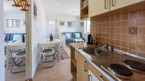 A modern kitchen with a large island, white cabinetry, and a tiled backsplash. - Apartment Vito (Njivice)