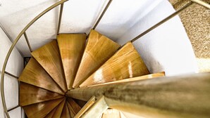 A spiral staircase with wooden steps and metal railings. - House Lea (Igrane)