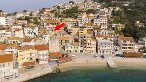 A coastal town with buildings, a beach, and a mountain in the background. - House Lea (Igrane)