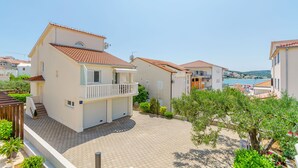 Ein Wohngebäude mit Balkon, befestigter Auffahrt und Meerblick.