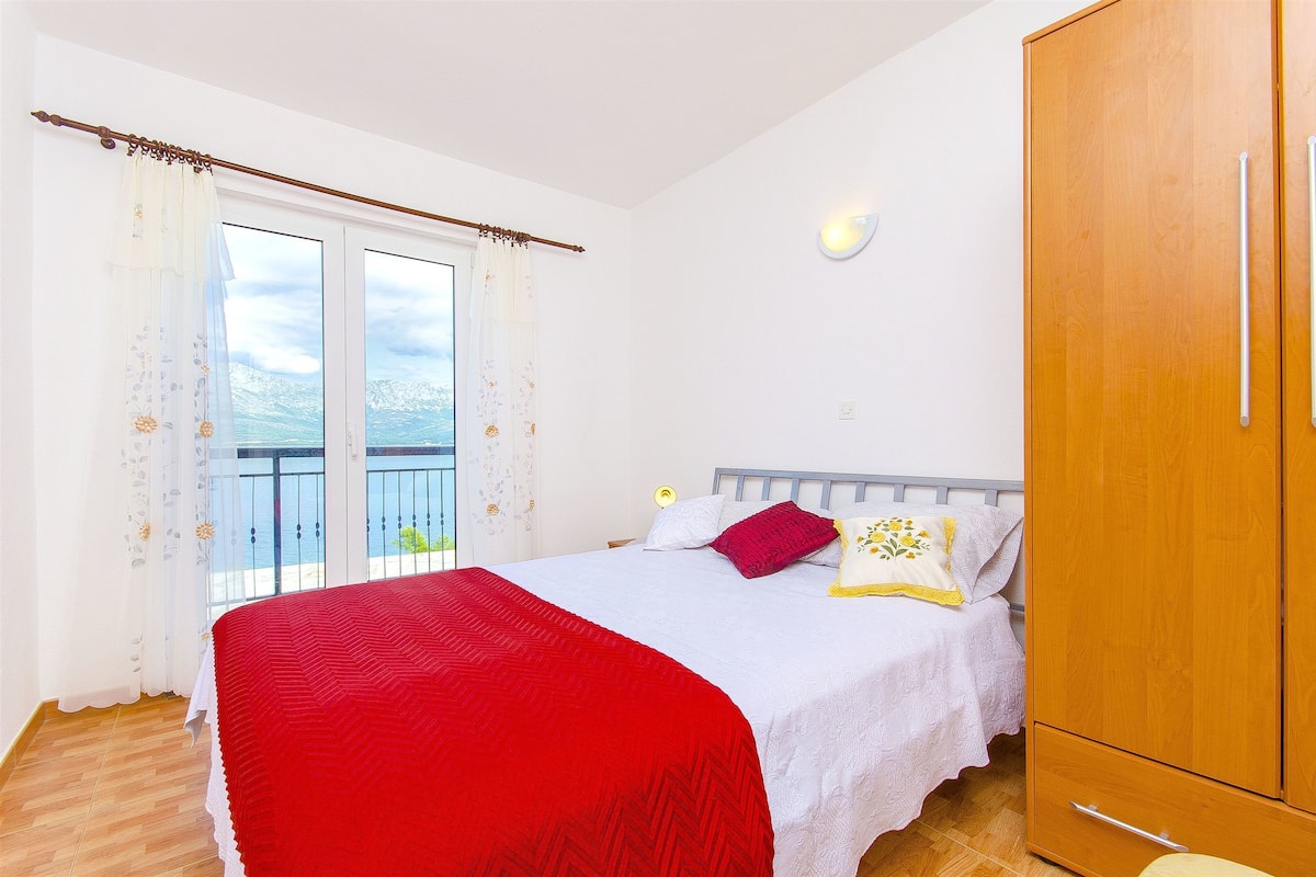 Un dormitorio con cama, armario y balcón con vistas.