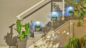 Un escalier agrémenté de plantes en pot et d’éclairages.