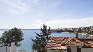 Une vue sur la côte, avec un ciel dégagé, une étendue d’eau et une ville en arrière-plan.