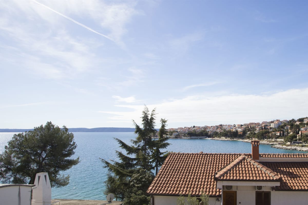 A coastal view with a clear sky, a body of water, and a town in the background.